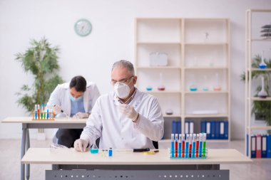 Salgın sırasında laboratuvarda çalışan iki erkek kimyager.