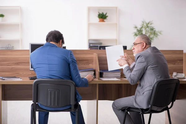 Twee mannelijke werknemers die op kantoor werken — Stockfoto