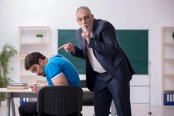 Viejo profesor y joven adicto al teléfono estudiante en el classro — Foto de Stock