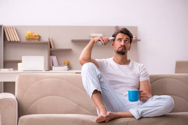 Genç erkek öğrenci salgın sırasında evde oturuyor.