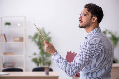 Sınıftaki genç erkek öğretmen.