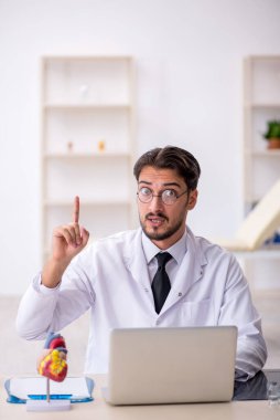 Klinikte çalışan genç bir erkek kardiyolog.