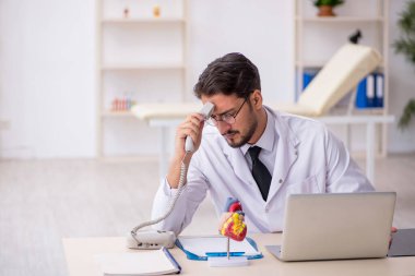 Klinikte çalışan genç bir erkek kardiyolog.