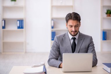 Ofiste çalışan genç bir erkek.