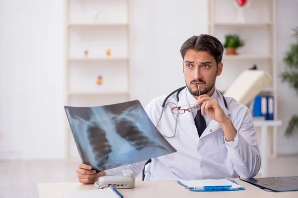 Ung manlig röntgenläkare som arbetar på kliniken — Stockfoto