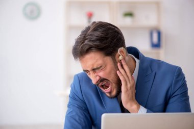 İşyerinde işitme cihazı kullanan sağır erkek çalışan