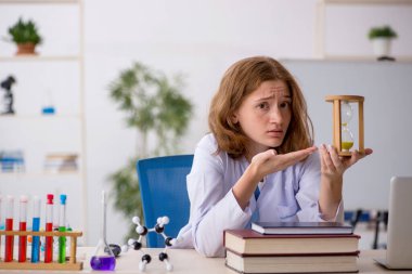 Zaman yönetimi konseptinde genç bayan kimyager.