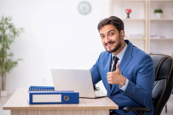 Dipendente maschio sordo che utilizza apparecchi acustici sul posto di lavoro — Foto Stock