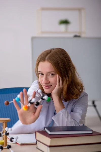 Jonge vrouwelijke chemicus studeert moleculair model — Stockfoto
