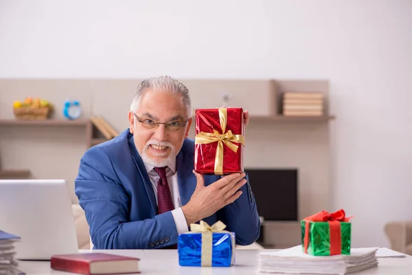 Velho funcionário do sexo masculino comemorando o Natal em casa — Fotografia de Stock