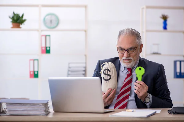 Anciano empleado en concepto de remuneración en el lugar de trabajo —  Fotos de Stock