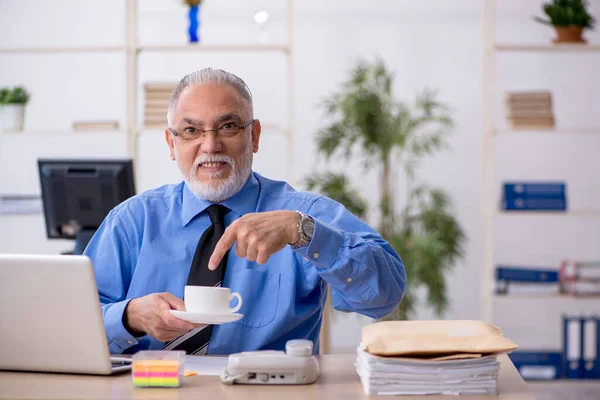 Starý muž zaměstnanec pití kávy během přestávky — Stock fotografie