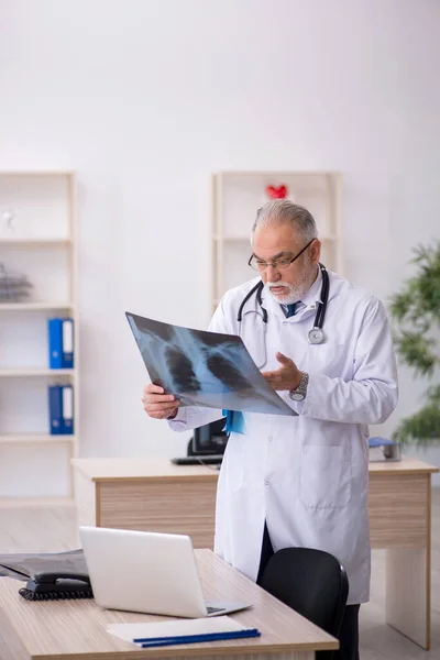 Gammal manlig röntgenläkare som arbetar på kliniken — Stockfoto