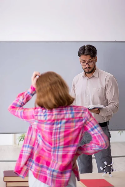 Mladý muž učitel a zrzka dívka ve třídě — Stock fotografie