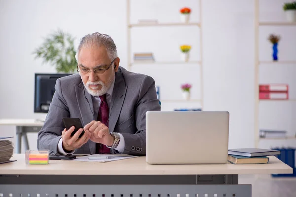 Gammal manlig anställd som sitter på kontoret — Stockfoto