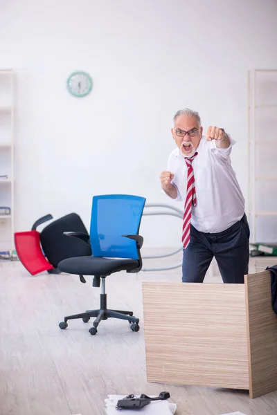 Gammal manlig anställd som arbetar övertid på kontoret — Stockfoto