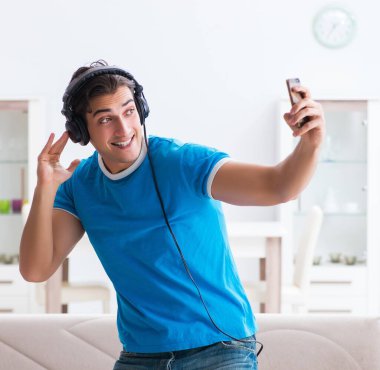 Genç yakışıklı adam evde karaoke yapıyor.