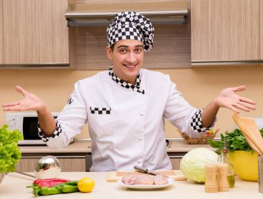 Genç aşçı mutfakta çalışıyor.