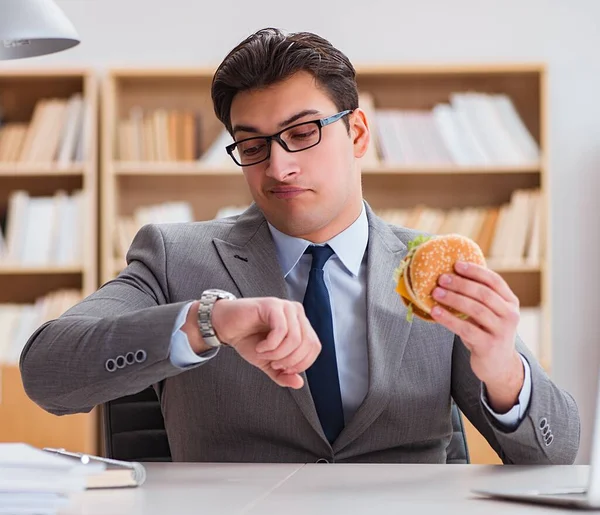 Hambriento empresario divertido comer sándwich de comida chatarra — Foto de Stock