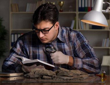 Arkeolog geç saatlere kadar ofiste çalışıyor.