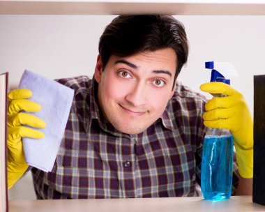 Kitaplıktaki tozları temizleyen adam