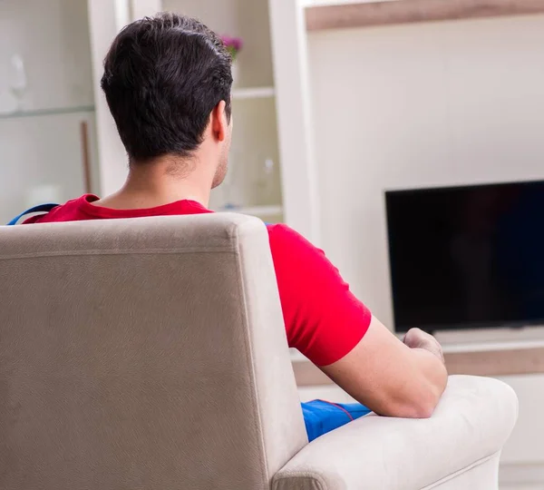 Jeune homme regardant la télévision à la maison — Photo