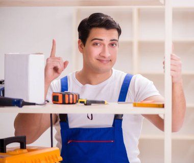 İşçi adam montaj kitaplığını tamir ediyor