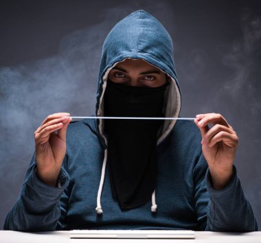 Bilgisayar korsanı karanlık odada çalışıyor.