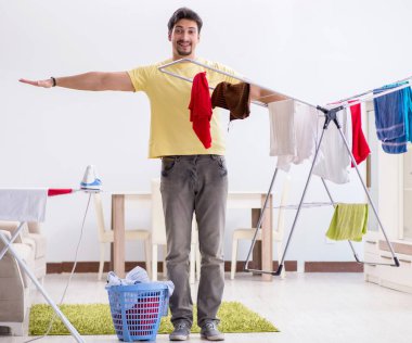 Yakışıklı koca evde çamaşır yıkıyor.