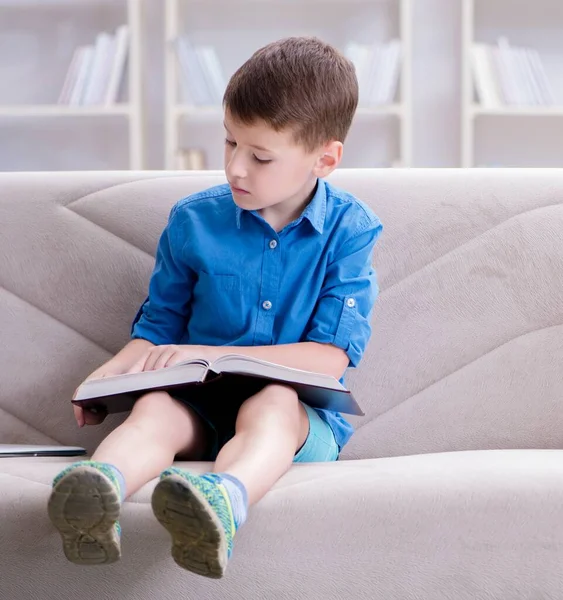 Liten pojke läser böcker hemma — Stockfoto