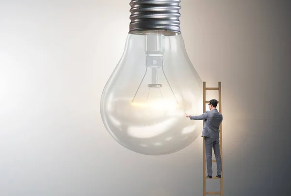 Podnikatel na žebříku se žárovkou — Stock fotografie