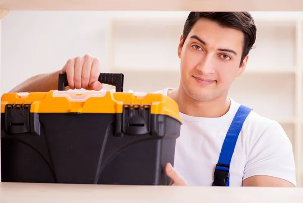 Arbeiter repariert Bücherregal — Stockfoto