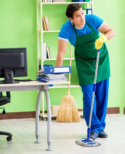 Άνδρας όμορφος επαγγελματίας καθαριστής κάνει σφουγγάρισμα στο γραφείο — Φωτογραφία Αρχείου