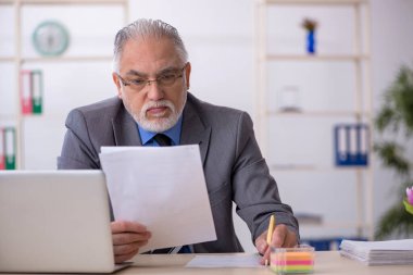 Ofiste çalışan yaşlı bir erkek.