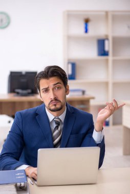 Ofiste çalışan genç bir erkek.