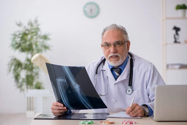 Gammal manlig röntgenläkare som arbetar på kliniken — Stockfoto