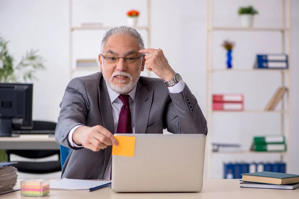 Öreg férfi alkalmazott ül az irodában — Stock Fotó