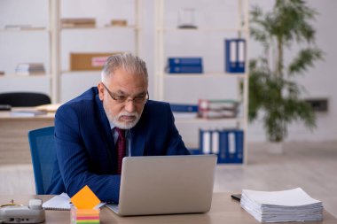 Ofiste çalışan yaşlı bir erkek.