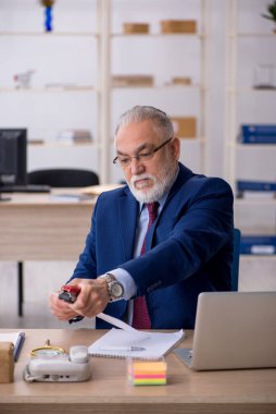 Ofiste çalışan yaşlı bir erkek.