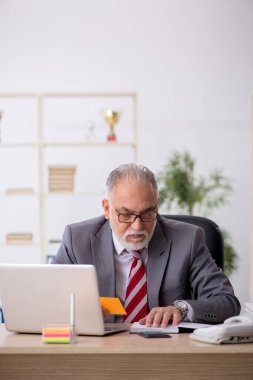 Ofiste çalışan yaşlı bir erkek.