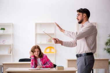 Sınıftaki genç erkek öğretmen ve kızıl saçlı kız.