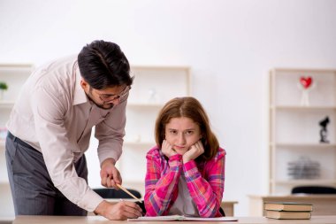 Sınıftaki genç erkek öğretmen ve kızıl saçlı kız.