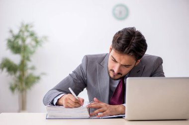 Ofiste çalışan genç bir erkek.