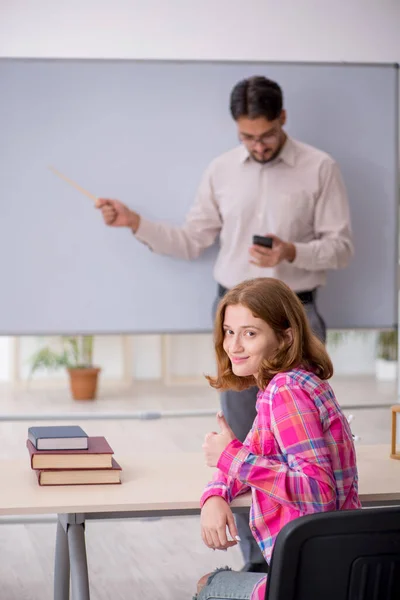 Jong man leraar en roodharige meisje in de klas — Stockfoto