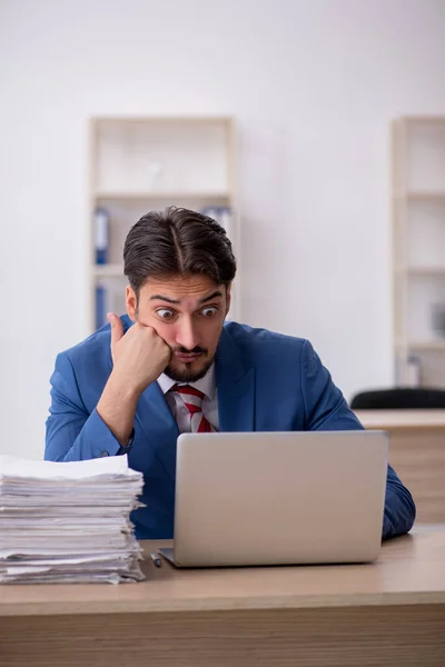 Jeune employé masculin et trop de travail au bureau — Photo