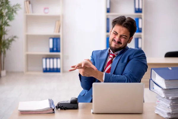 Junge männliche Mitarbeiter und zu viel Arbeit im Büro — Stockfoto