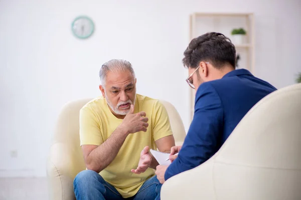 Yaşlı adam genç erkek psikoterapisti ziyaret ediyor. — Stok fotoğraf
