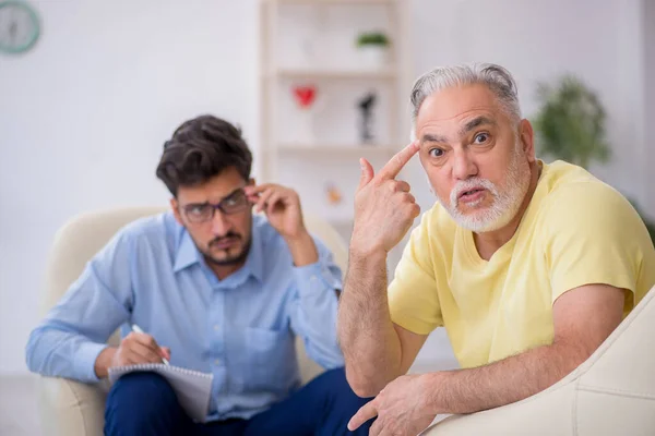 Starý muž navštíví mladého mužského psychoterapeuta — Stock fotografie