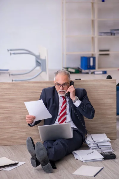 Ofiste fazla mesai yapan eski bir erkek işçi. — Stok fotoğraf