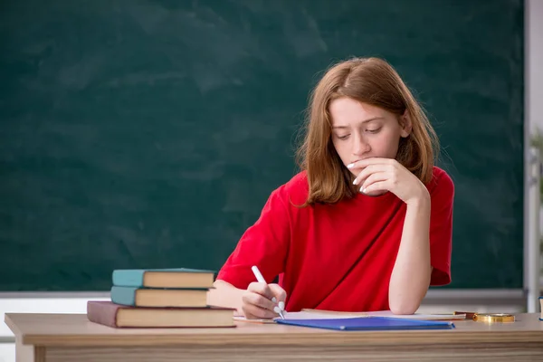 Jonge vrouwelijke student bereidt zich voor op examens in de klas — Stockfoto